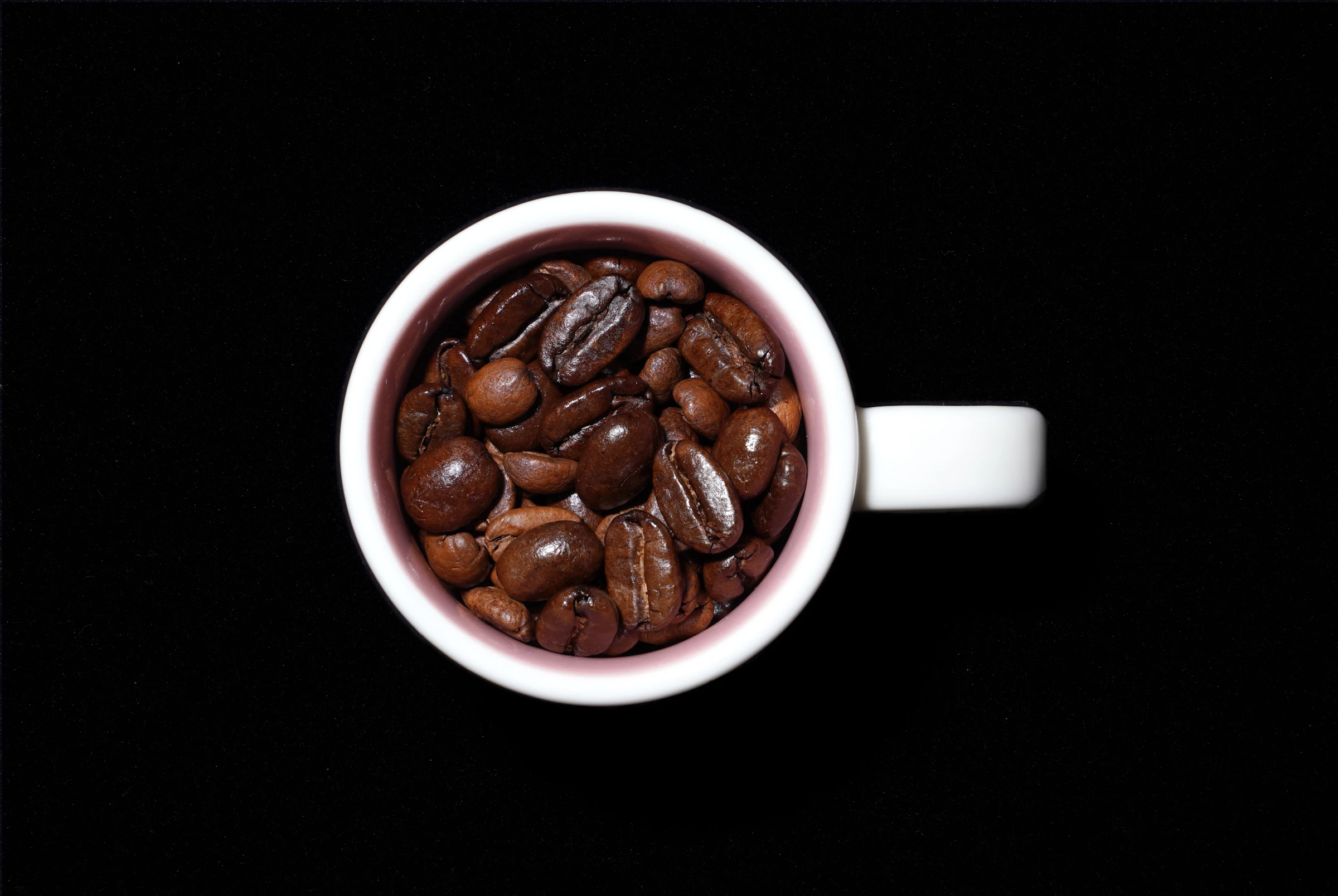 Xícara de café especial com grãos sobre fundo escuro